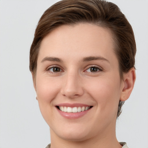 Joyful white young-adult female with short  brown hair and grey eyes