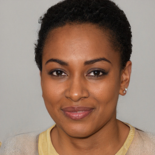 Joyful black young-adult female with short  black hair and brown eyes