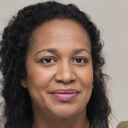 Joyful black adult female with long  brown hair and brown eyes