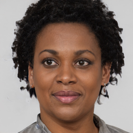Joyful black adult female with short  brown hair and brown eyes