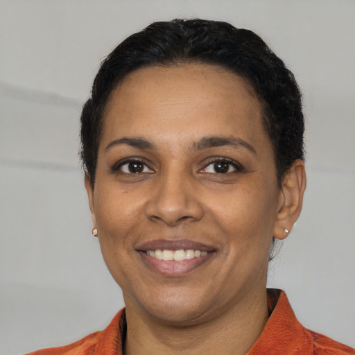Joyful black young-adult female with short  black hair and brown eyes