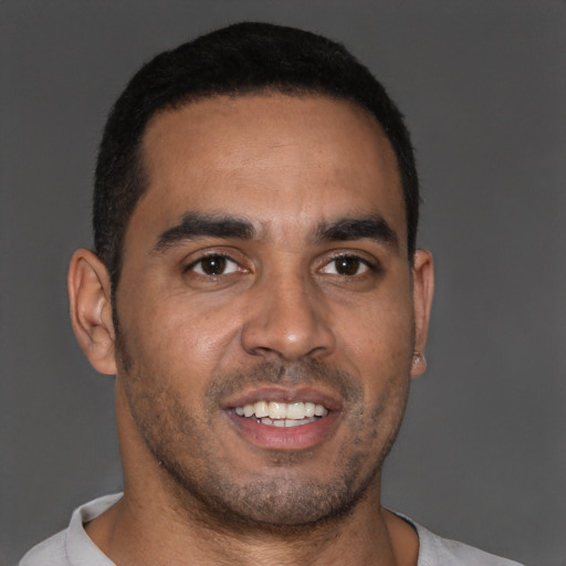 Joyful black young-adult male with short  brown hair and brown eyes