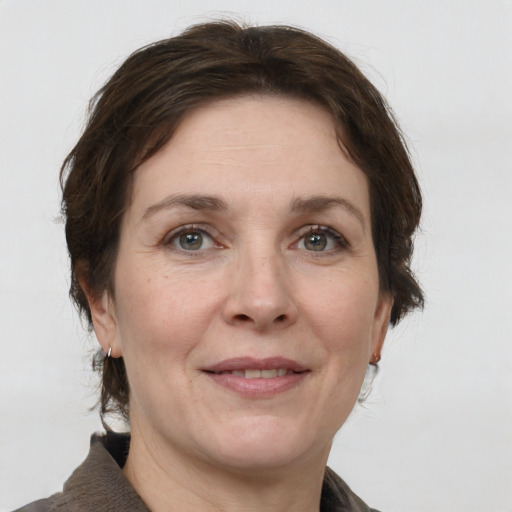 Joyful white adult female with short  brown hair and grey eyes