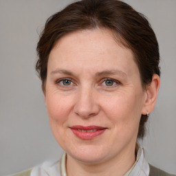 Joyful white adult female with medium  brown hair and grey eyes