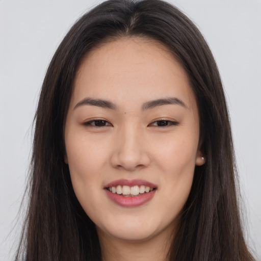 Joyful asian young-adult female with long  brown hair and brown eyes