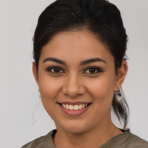 Joyful latino young-adult female with medium  brown hair and brown eyes