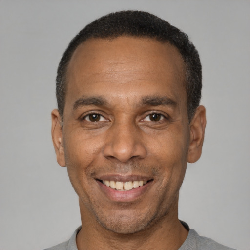 Joyful latino adult male with short  black hair and brown eyes