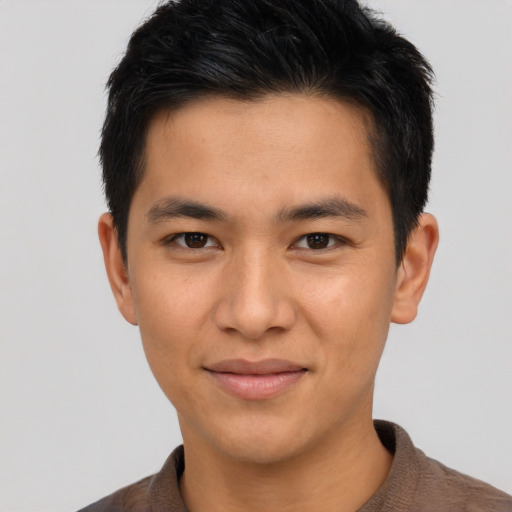 Joyful asian young-adult male with short  brown hair and brown eyes