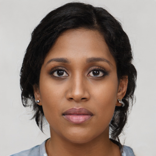 Joyful black young-adult female with long  black hair and brown eyes