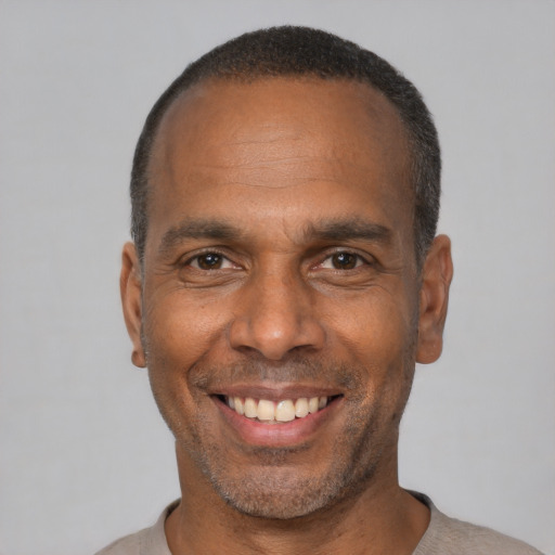 Joyful black adult male with short  black hair and brown eyes