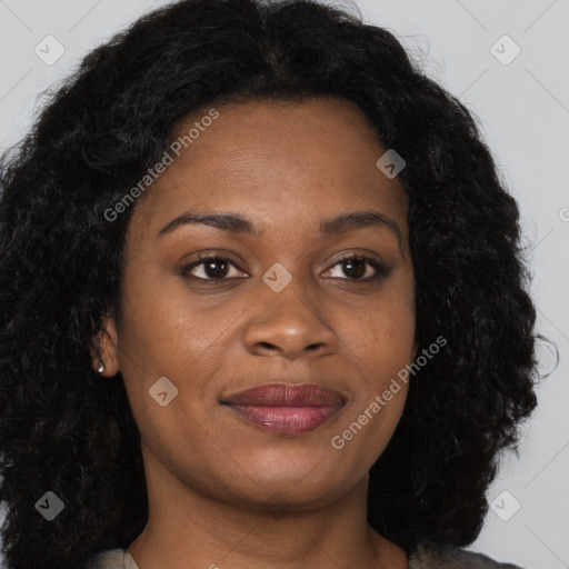 Joyful black young-adult female with long  brown hair and brown eyes