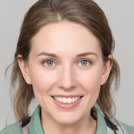 Joyful white young-adult female with medium  brown hair and blue eyes