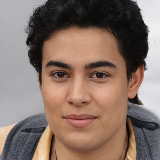Joyful latino young-adult male with short  brown hair and brown eyes