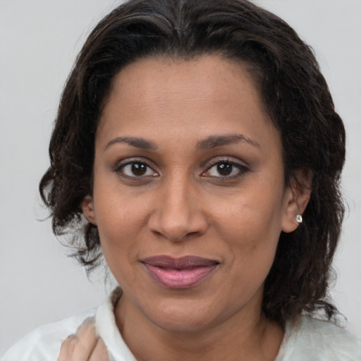 Joyful latino adult female with medium  brown hair and brown eyes