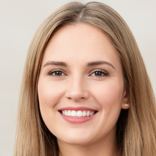 Joyful white young-adult female with long  brown hair and brown eyes