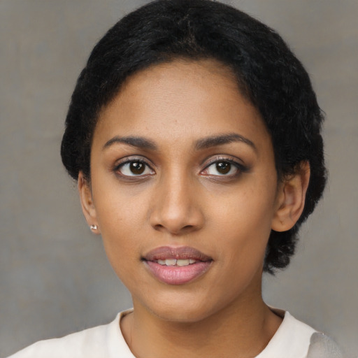 Joyful black young-adult female with short  black hair and brown eyes