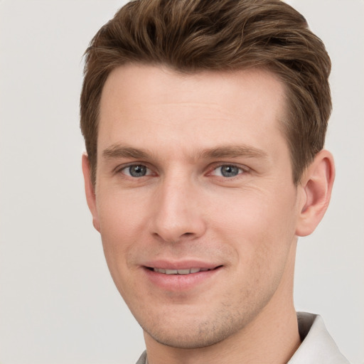 Joyful white young-adult male with short  brown hair and grey eyes