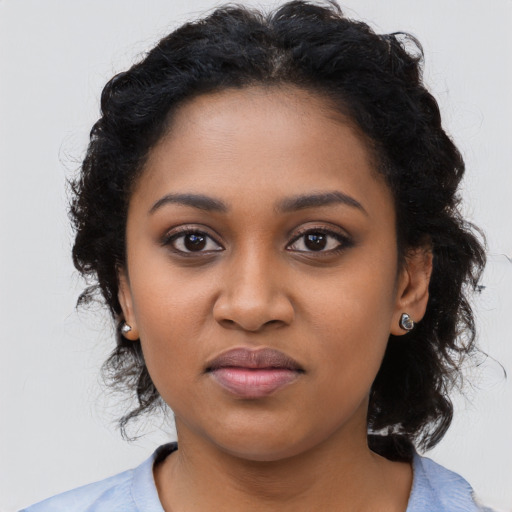 Joyful black young-adult female with long  black hair and brown eyes