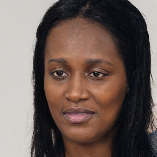 Joyful black young-adult female with long  black hair and brown eyes