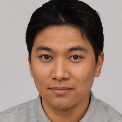 Joyful asian young-adult male with short  black hair and brown eyes