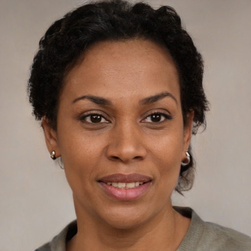 Joyful latino adult female with short  brown hair and brown eyes