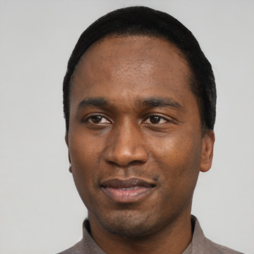 Joyful black young-adult male with short  black hair and brown eyes