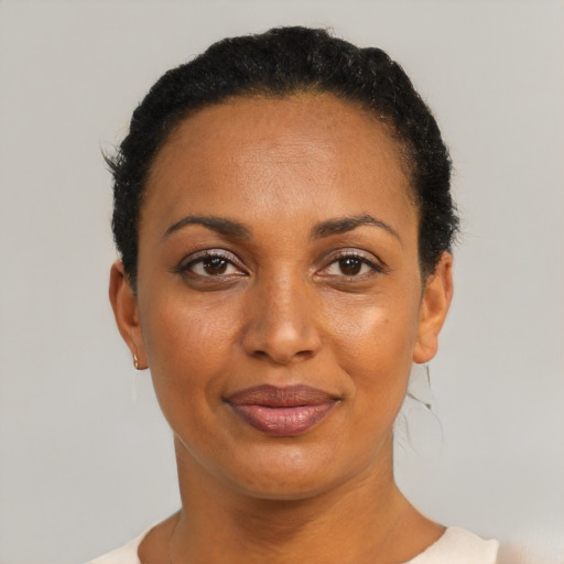 Joyful black adult female with short  black hair and brown eyes