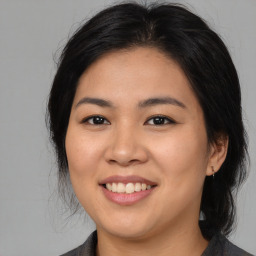 Joyful asian young-adult female with medium  brown hair and brown eyes