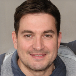 Joyful white adult male with short  brown hair and brown eyes