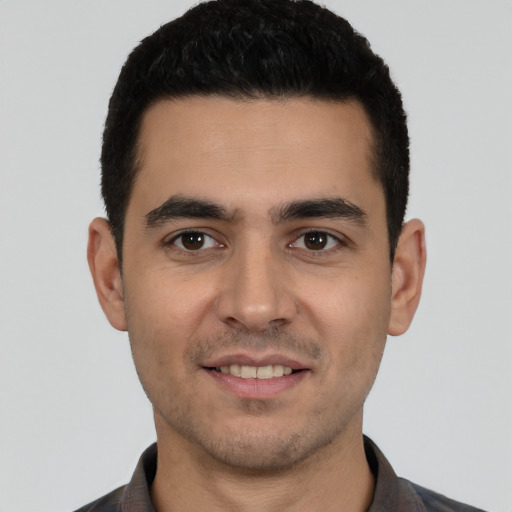 Joyful white young-adult male with short  black hair and brown eyes
