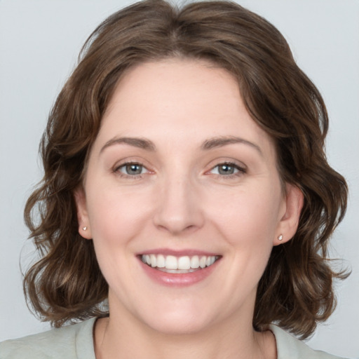 Joyful white young-adult female with medium  brown hair and blue eyes