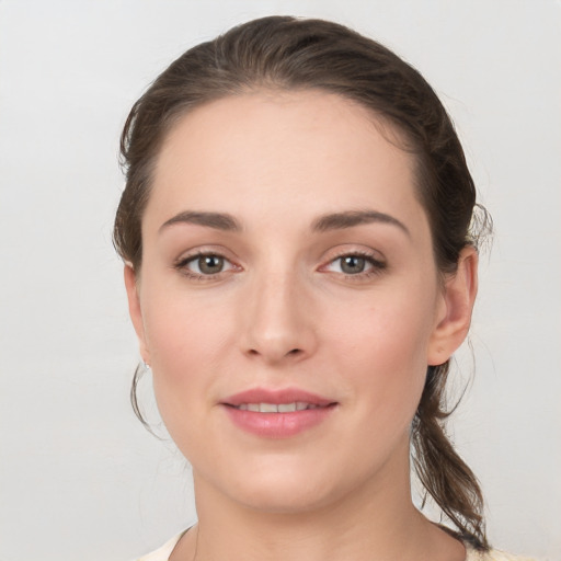 Joyful white young-adult female with medium  brown hair and grey eyes