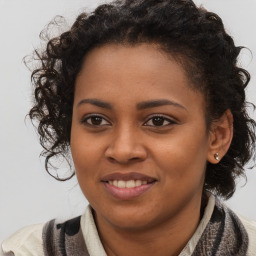 Joyful black young-adult female with long  brown hair and brown eyes