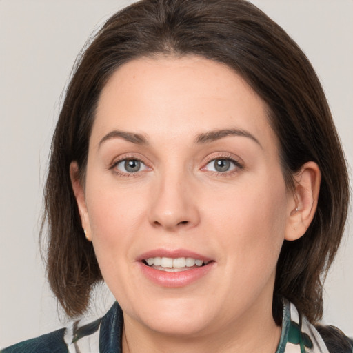 Joyful white young-adult female with medium  brown hair and grey eyes