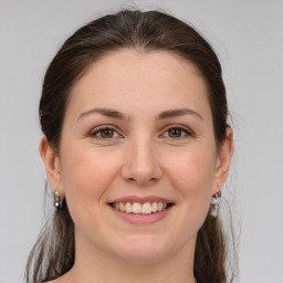 Joyful white young-adult female with medium  brown hair and grey eyes