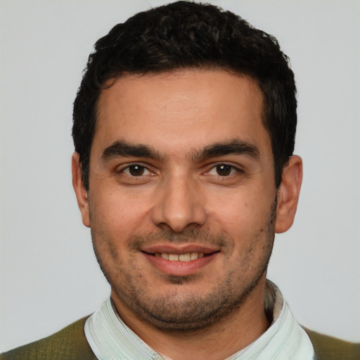 Joyful white young-adult male with short  black hair and brown eyes