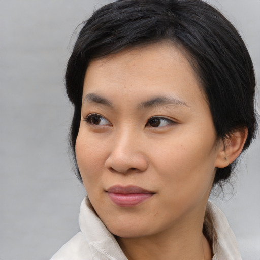 Joyful asian young-adult female with medium  black hair and brown eyes