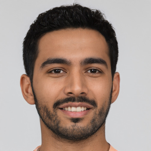 Joyful latino young-adult male with short  black hair and brown eyes