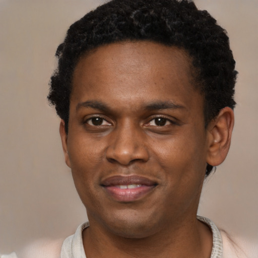 Joyful black young-adult male with short  brown hair and brown eyes