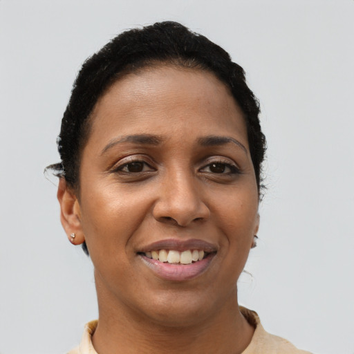 Joyful black young-adult female with short  black hair and brown eyes