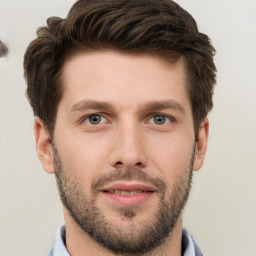 Joyful white young-adult male with short  brown hair and grey eyes