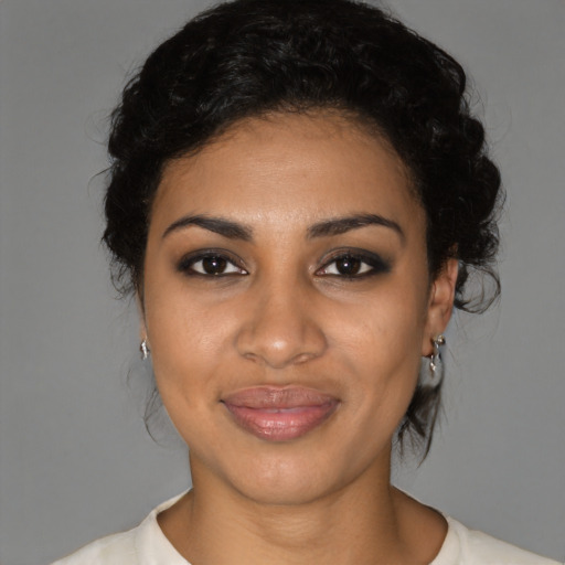 Joyful black young-adult female with medium  brown hair and brown eyes