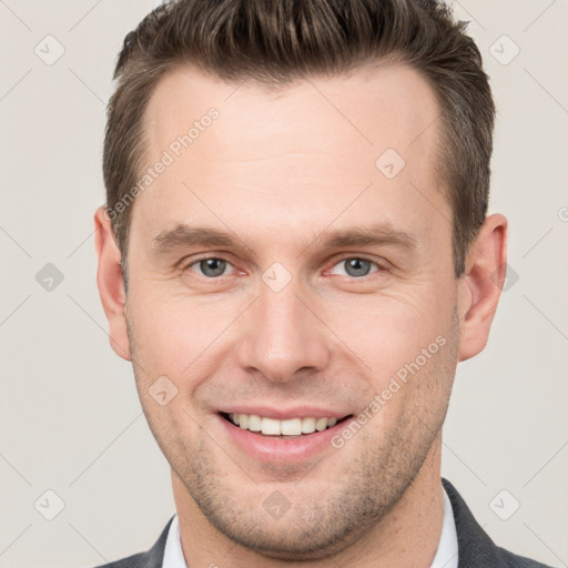 Joyful white young-adult male with short  brown hair and grey eyes