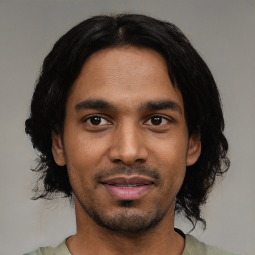 Joyful black young-adult male with medium  black hair and brown eyes