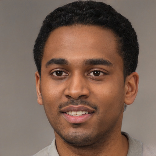 Joyful black young-adult male with short  black hair and brown eyes