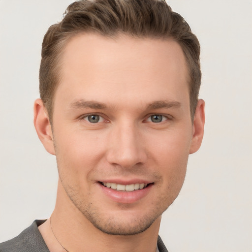 Joyful white young-adult male with short  brown hair and grey eyes