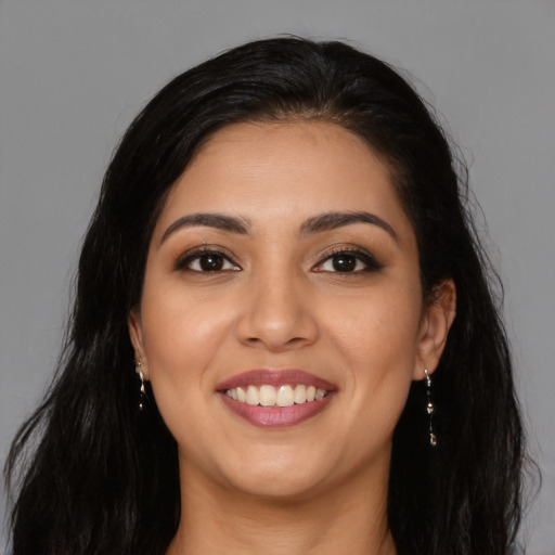 Joyful latino young-adult female with long  brown hair and brown eyes