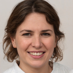 Joyful white young-adult female with medium  brown hair and green eyes