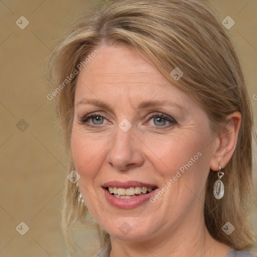 Joyful white adult female with medium  brown hair and blue eyes