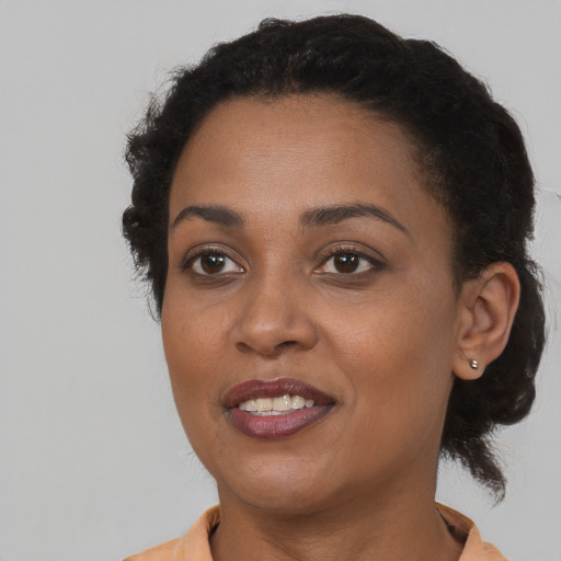 Joyful black young-adult female with short  brown hair and brown eyes